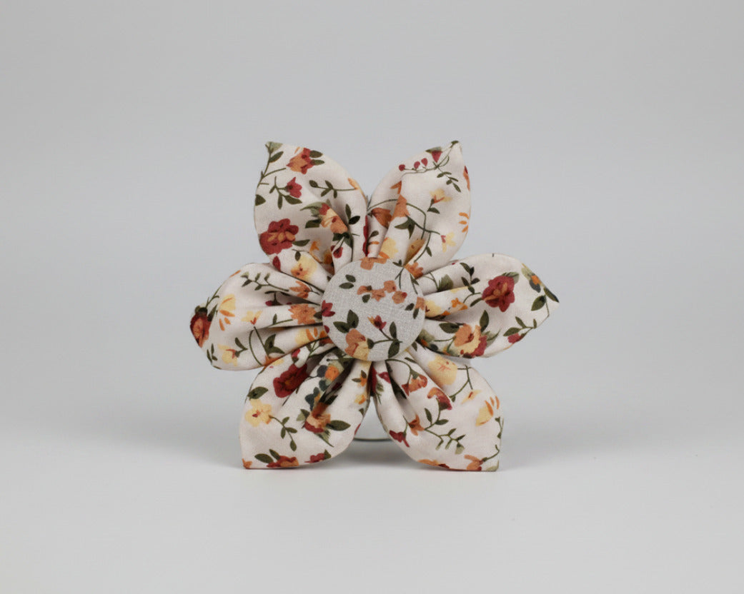 Floral bowtie accessory with layered knot shape, ivory base and small blossom print
