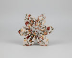Floral bowtie accessory with layered knot shape, ivory base and small blossom print