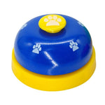 Blue pet training bell with yellow paw button and white paw-print decals