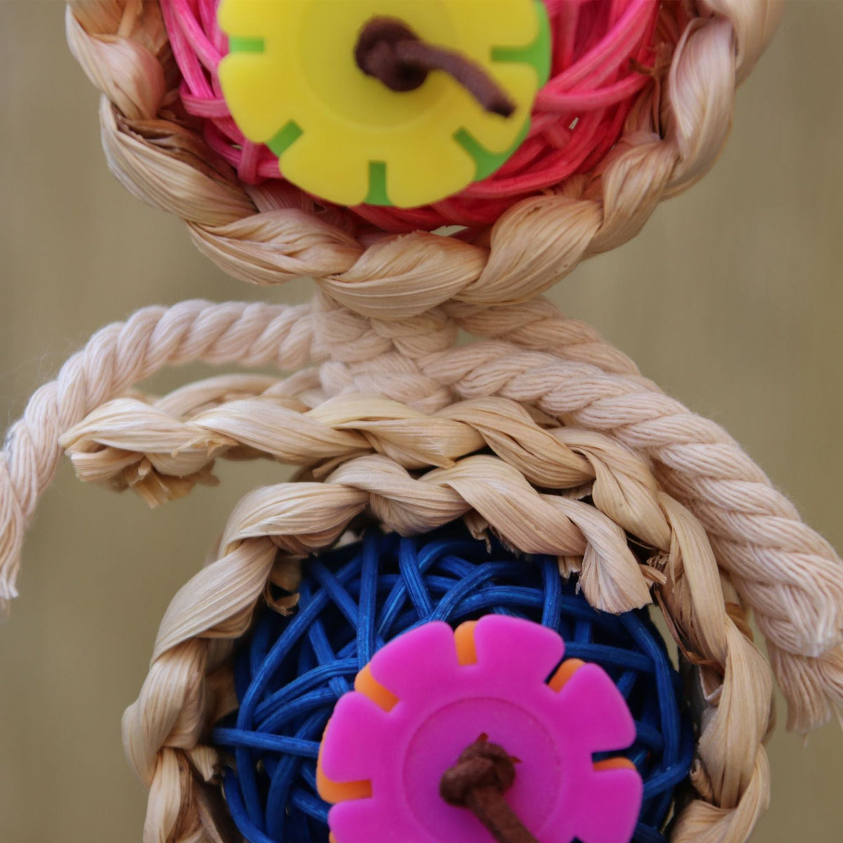 Close-up of braided vine ball with blue rope and pink gear wheel insert