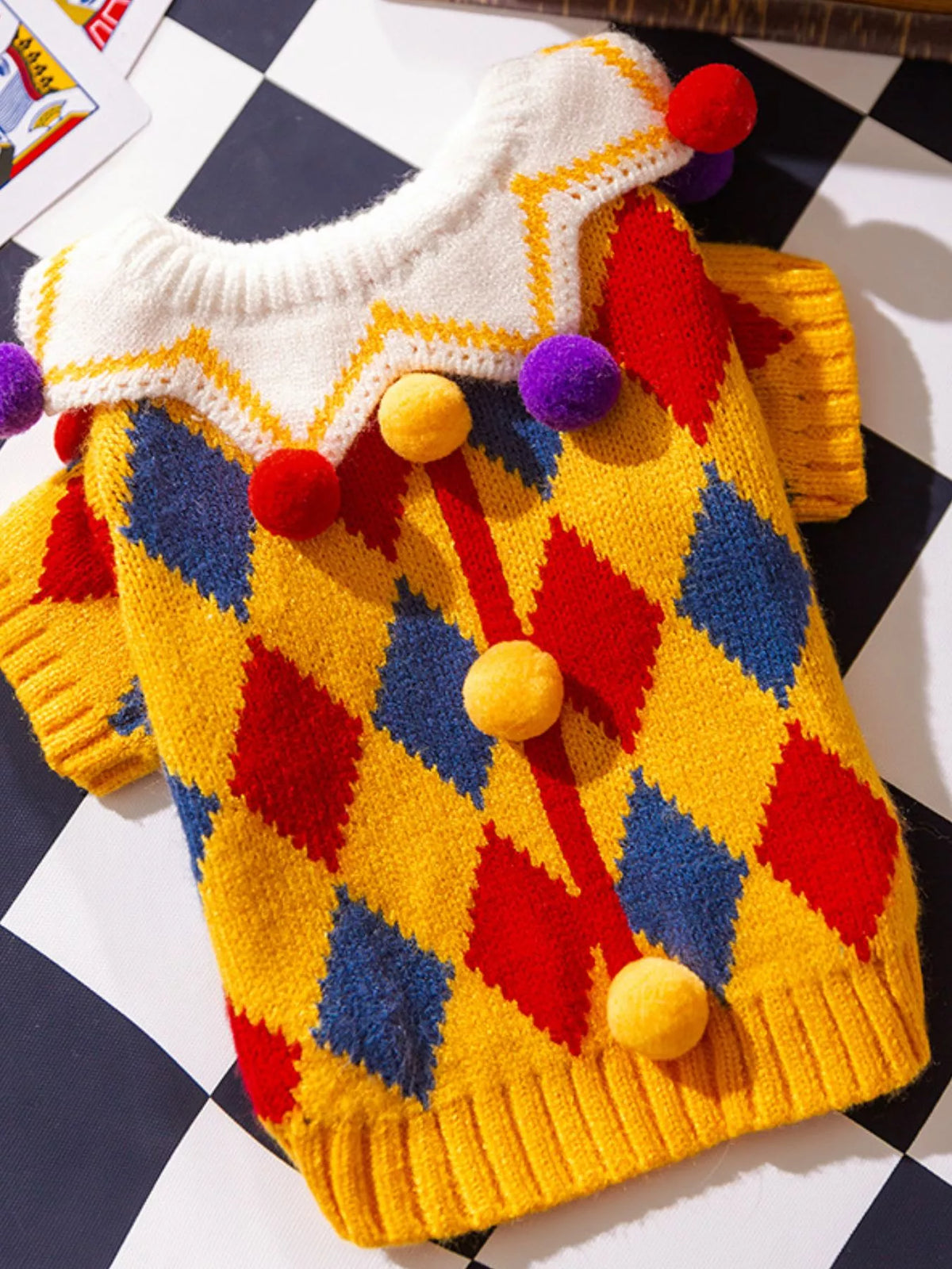 Multicolor zigzag knitted pet sweater with pom-pom accents and ribbed edges
