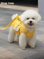 Yellow portable pet carrier harness with front pocket, worn on a small white dog