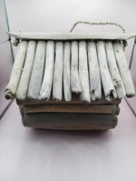 Rustic birdhouse with open roof slats and twine handle, front side view