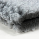 Close-up of gray fleece mat pet bed texture with soft tufted surface