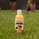 Apricot Kernel exfoliating & moisturizing pet shampoo bottle in orange on grass, white cap.