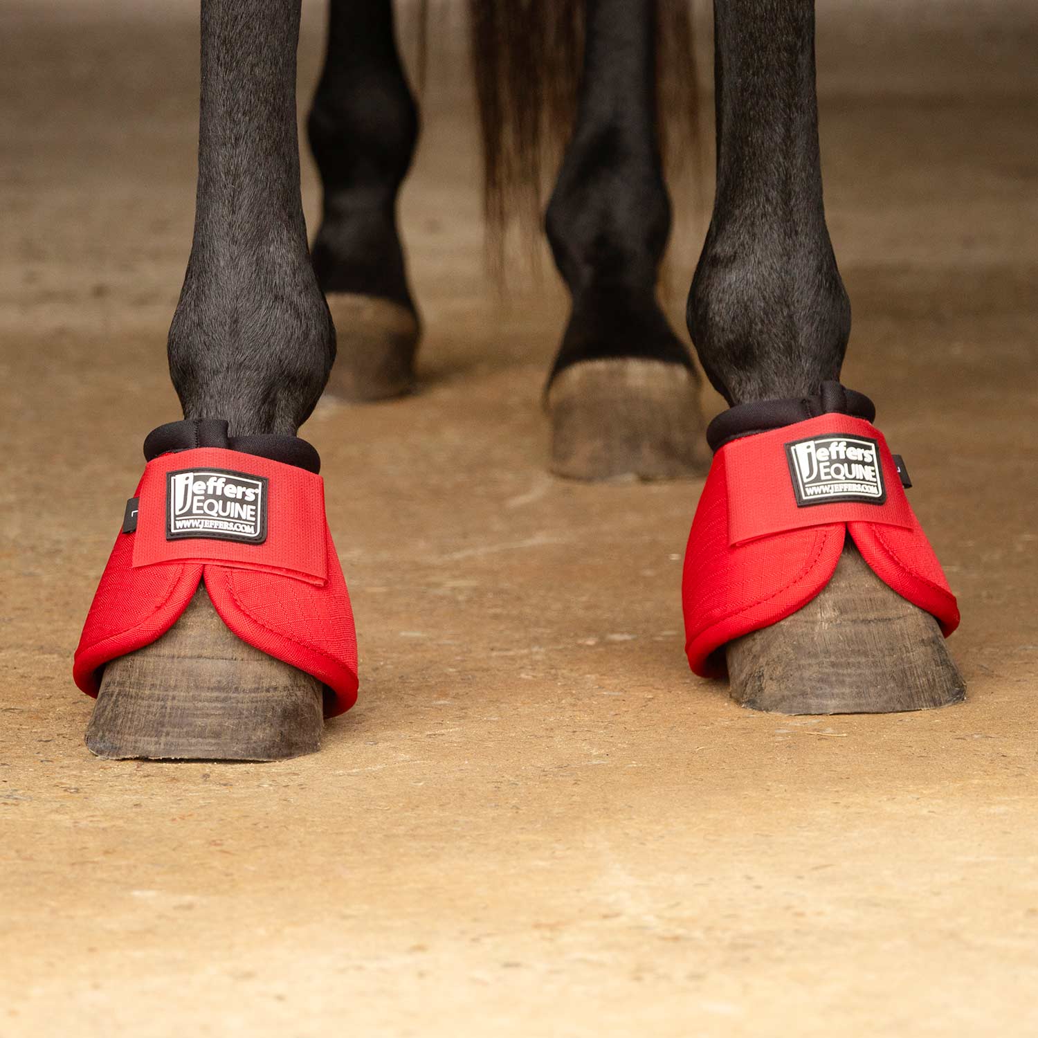 Red no-turn bell boots on horse hooves with padded cuffs and Jeffer's Equine logos.
