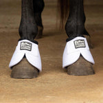 White no-turn bell boots on horse hooves with padded cuffs and front wrap straps