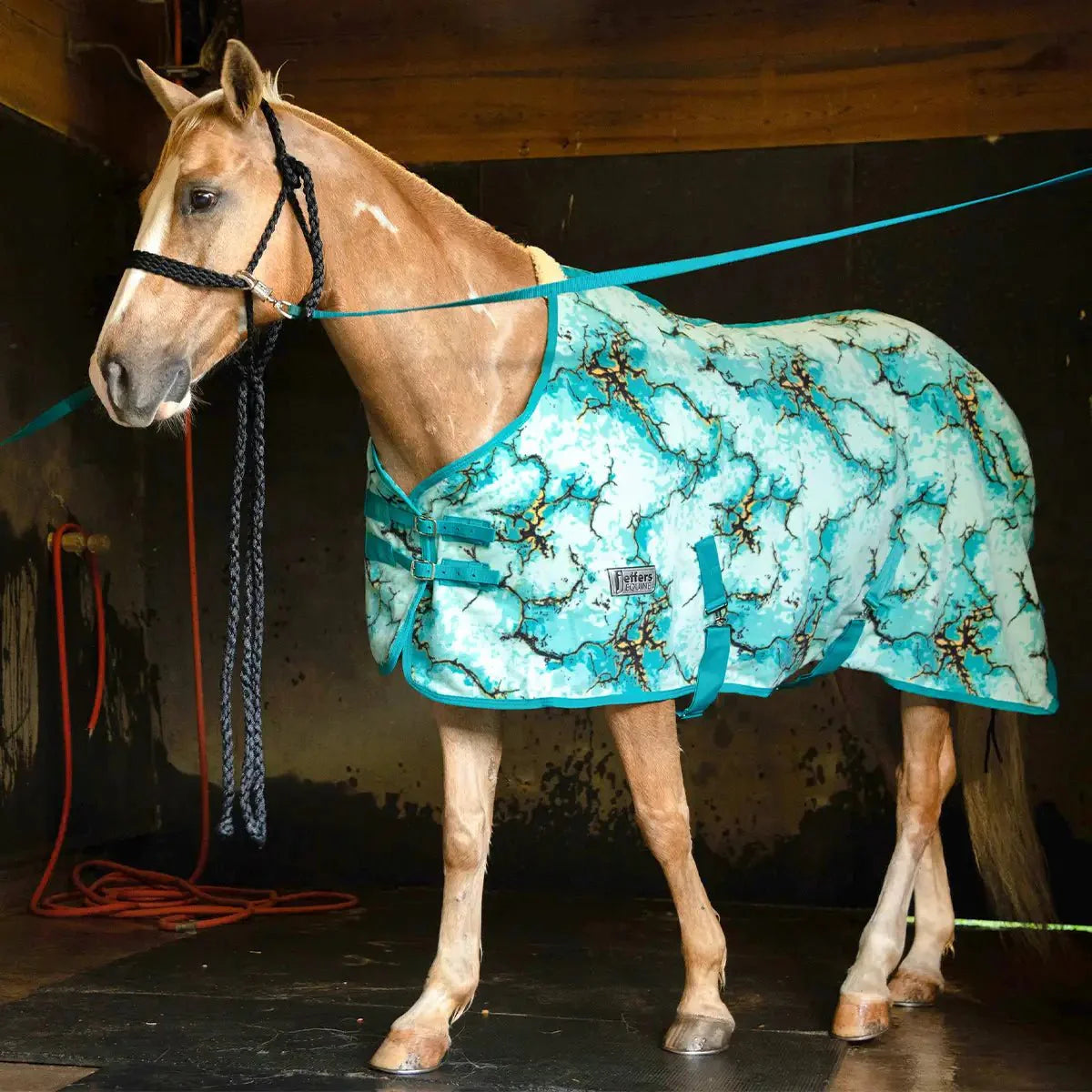 Teal fleece horse cooler with cloud-like pattern and teal straps