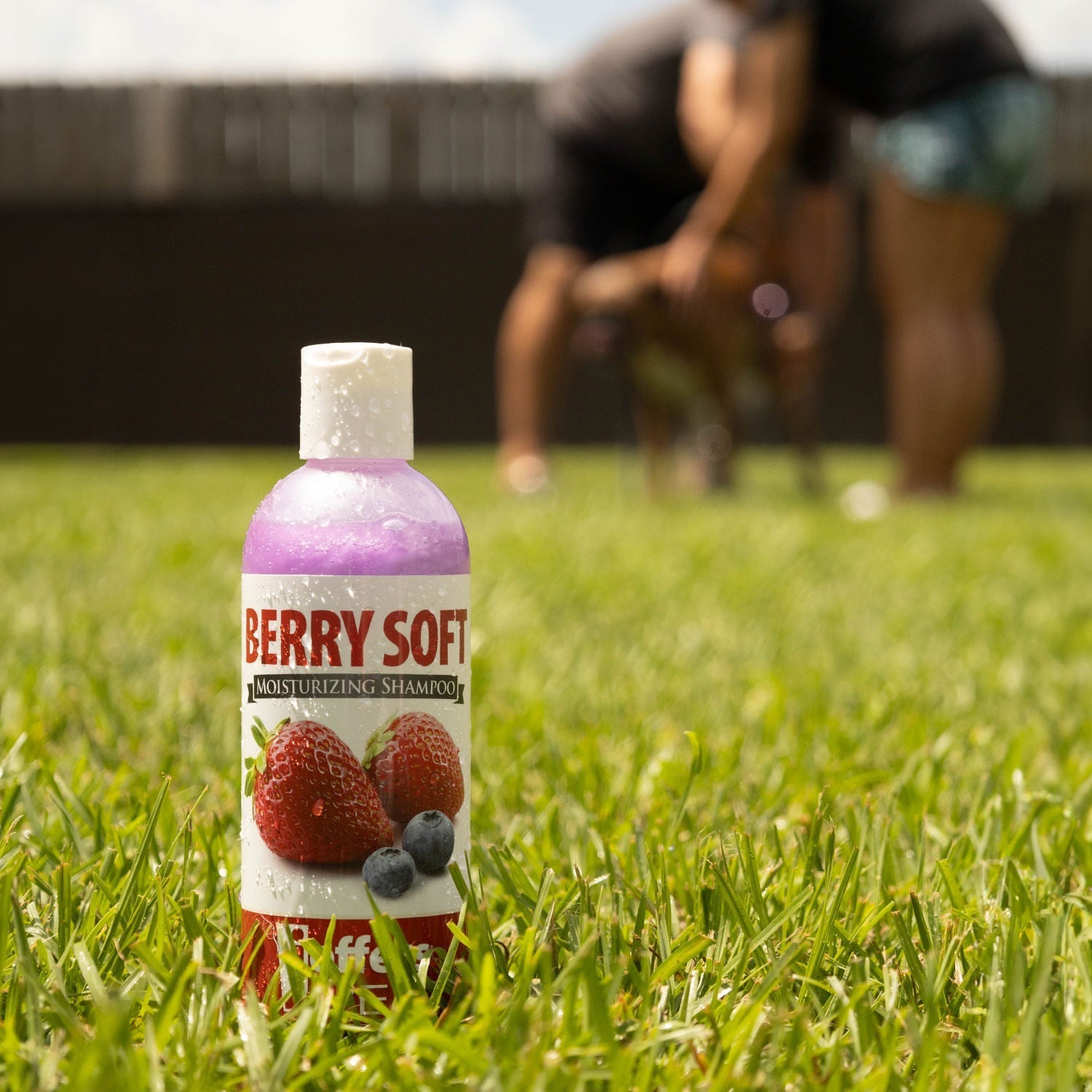 Pet moisturizing shampoo bottle, Berry Soft scent, standing in grass outdoors.