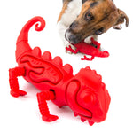 Red chameleon-shaped natural rubber dog chew toy with textured ridges and tail