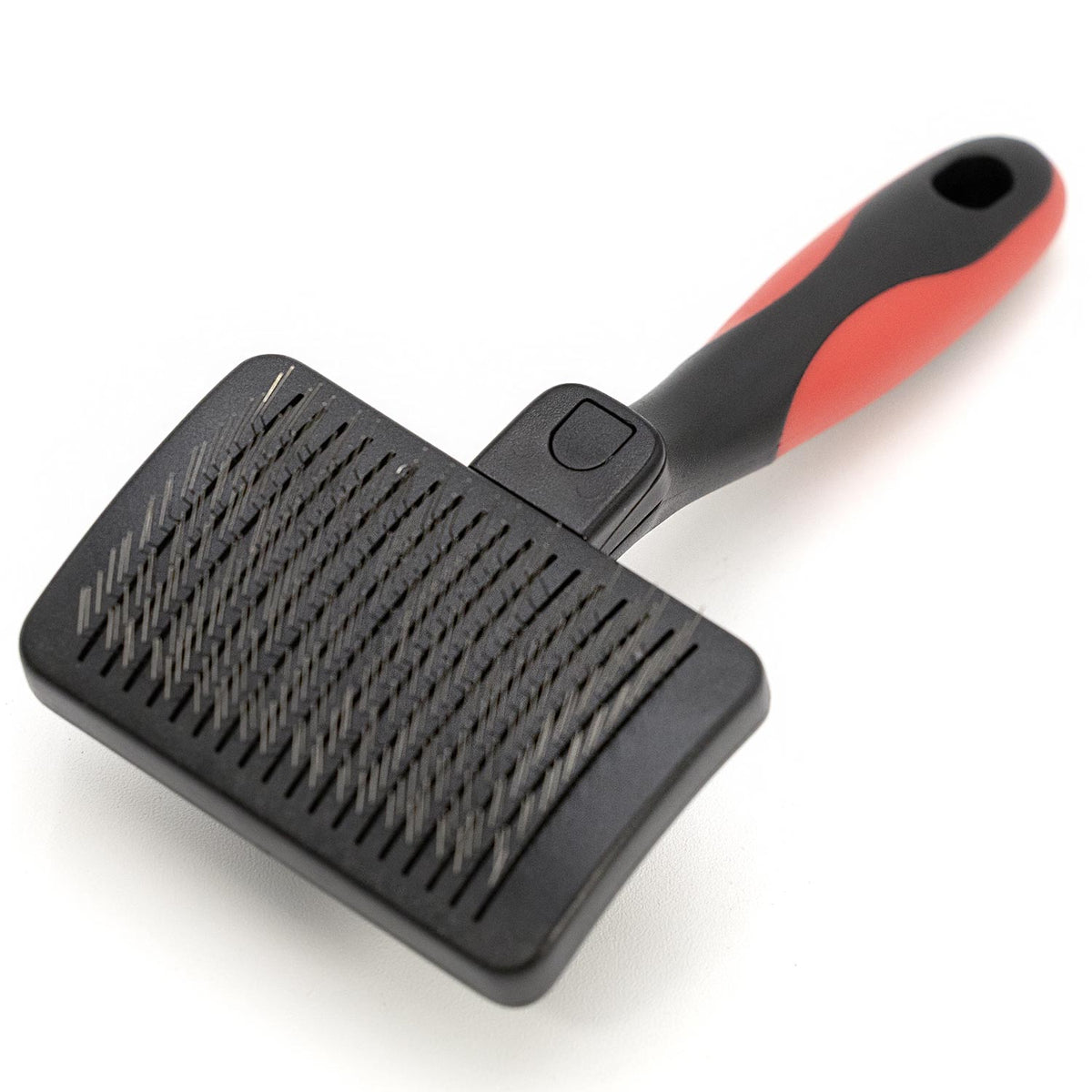 Slicker grooming brush with black pad, metal pins, and red-and-black grip handle
