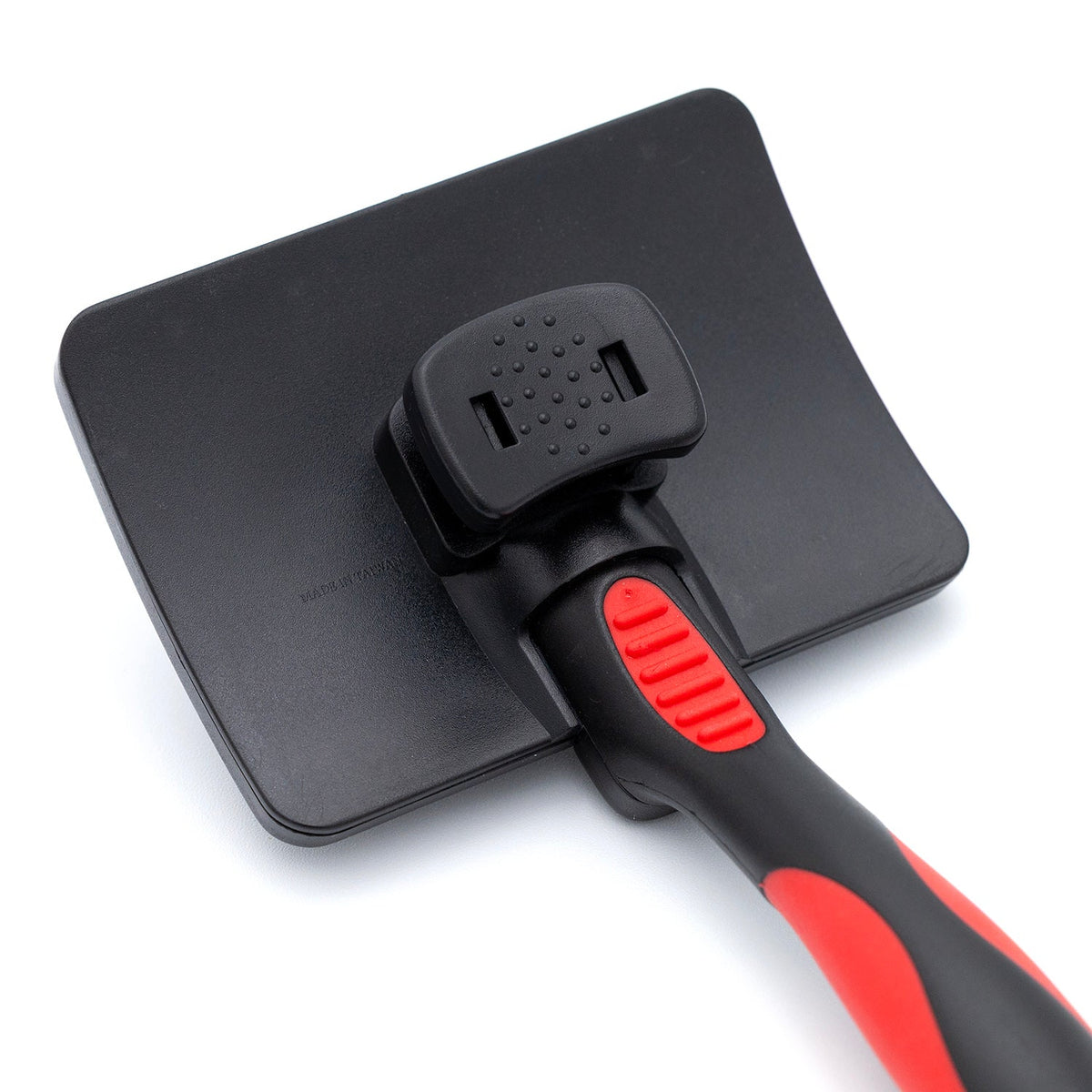 Self-cleaning slicker brush head with red button and black-and-red handle