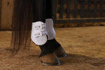 Pair of white fetlock boots worn on horse legs with buckle closures