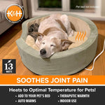 Grey heated pet bed with power cord, dog resting on the warm pad