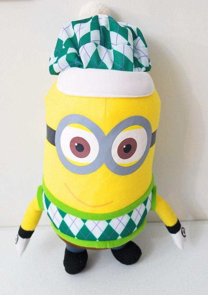 Yellow Minion plush wearing a green argyle scarf and white cap with blue trim.