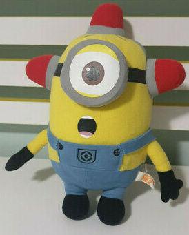Yellow Minion plush with blue overalls and red-and-white cap, round gray goggles.