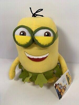 Yellow Minion plush with oversized green goggles and green ruffled collar, smiling.