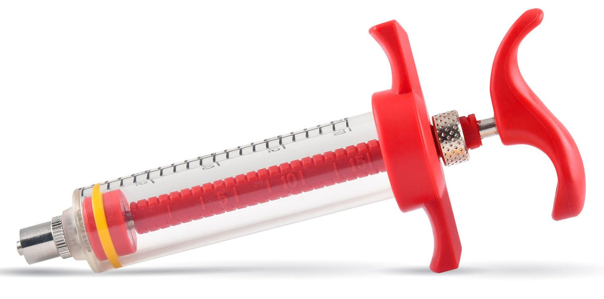 Red nylon syringe with clear barrel, thumb handles, and metal dispensing tip