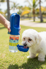 Blue portable dog bottle with palm graphics; hand holding for dog drinking