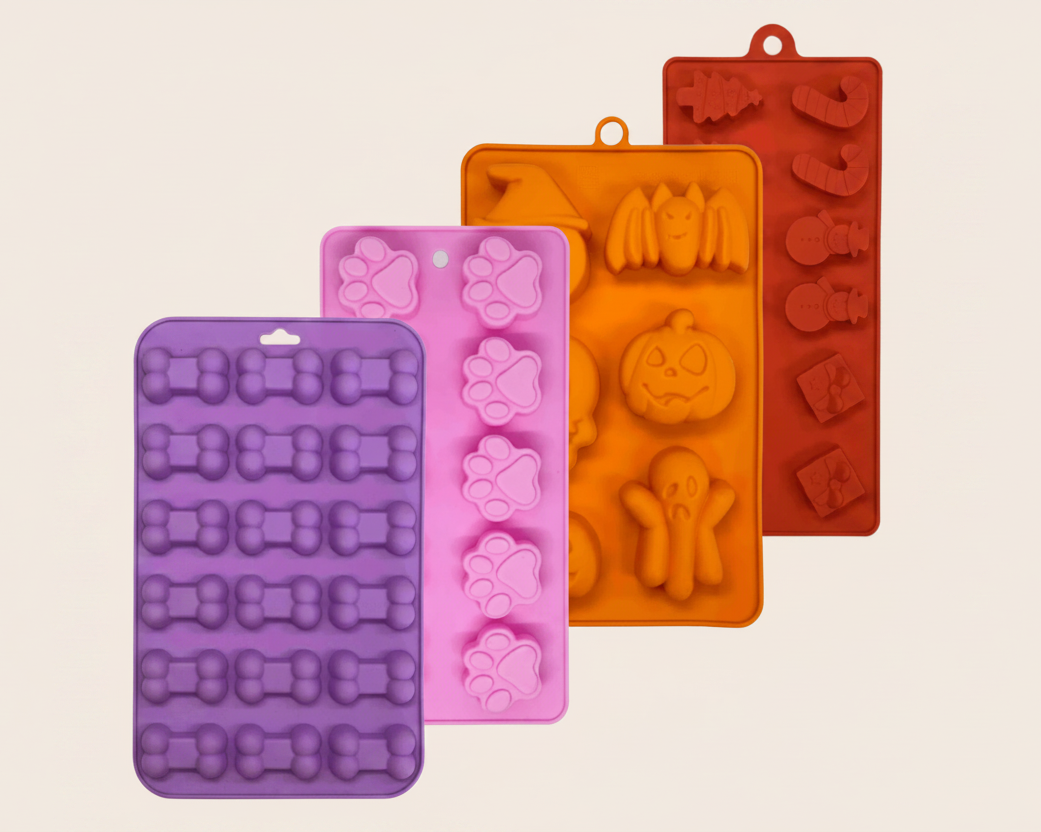 Silicone pet treat molds set: purple, pink, orange, and red trays with dog shapes.