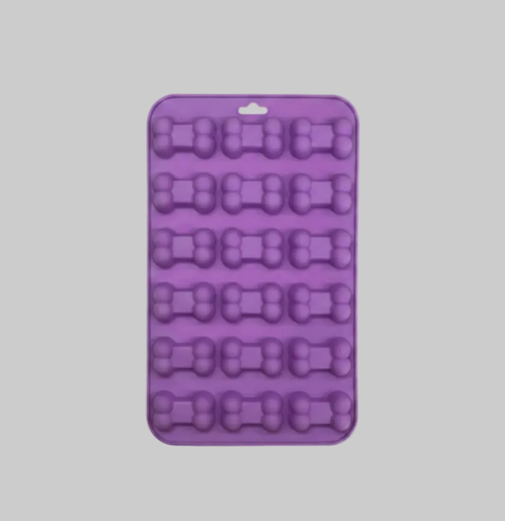 Purple silicone pet treat mold with bone-shaped cavities in a square tray.