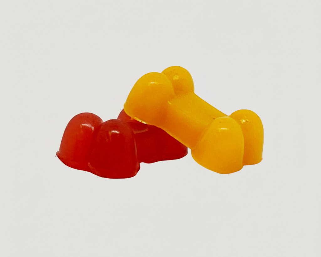 Assorted silicone pet treat pieces in red and yellow, bone-shaped treats.