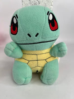 Stuffed plush dog toy, mint green cat-like character with black-red face markings and stitched smile
