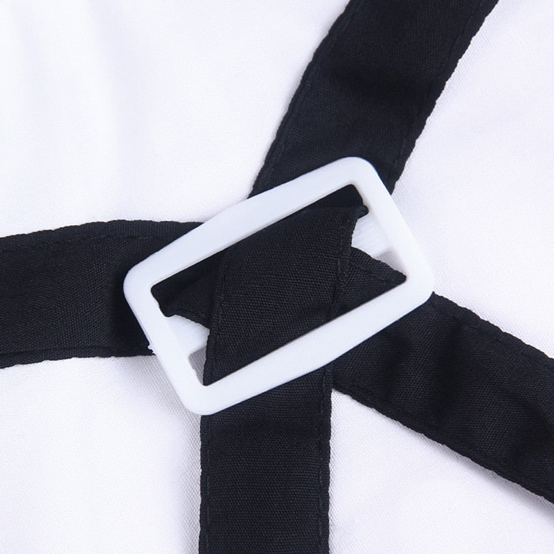 Close-up of black overalls strap and white button detail on pet suit