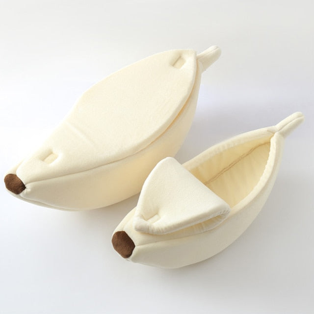Cream banana-shaped pet bed with plush interior and curved bolster cushions