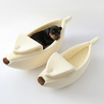 Cream banana-shaped plush pet bed set of 2 with dogs resting inside