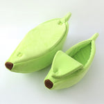 Light green banana-shaped pet bed with plush bolster cushions and rounded opening