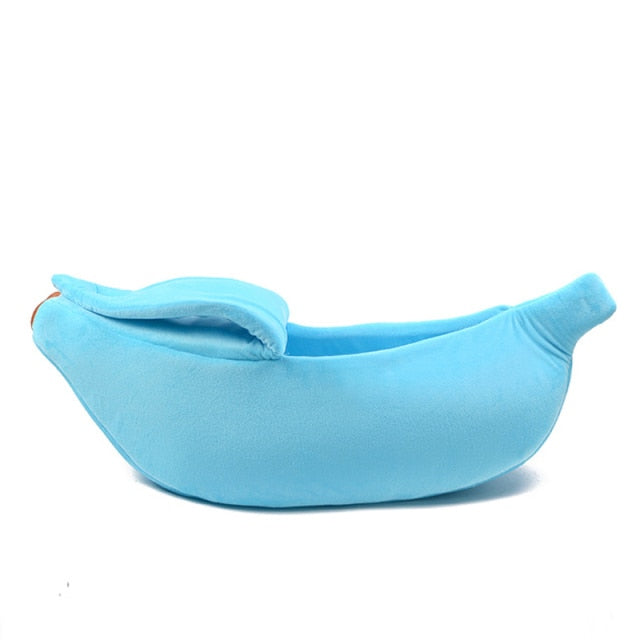 Light blue banana-shaped pet bed with plush bolster cushions and stitched opening