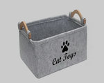 Light grey felt storage basket with cat paw emblem and wooden handle straps
