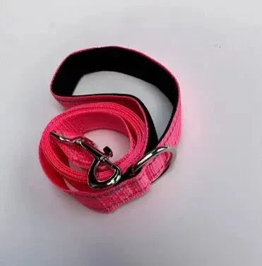 Bright pink pet leash with metal clasp and looped webbing, black backing visible