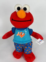 Red plush character dog toy with blue shirt and illustrated fish graphic