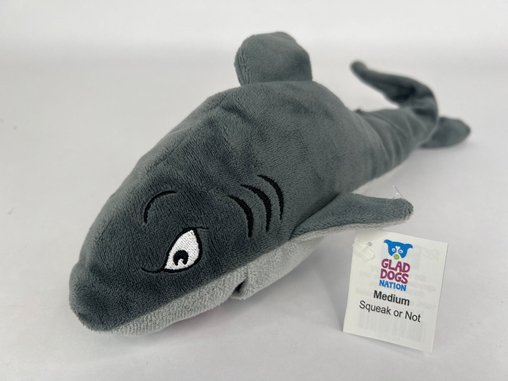 Gray dolphin plush dog toy with squeeze squeaker and Glad Dogs tag