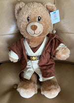 Brown teddy dog toy with Star Wars-style vest and hoodie, plush face and tag