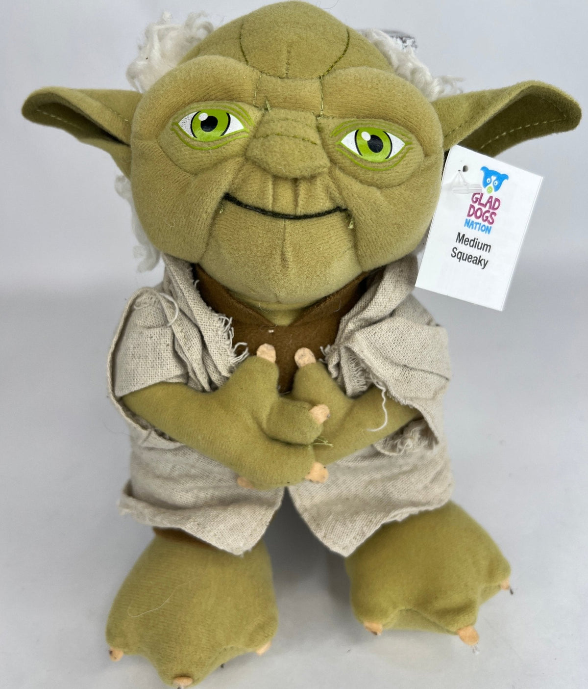 Yoda-style green plush dog toy with big green eyes, gray outfit, and crossed arms
