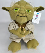 Yoda-style green plush dog toy with big green eyes, gray outfit, and crossed arms