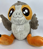 Porg-style plush dog toy with white fur, orange ear patches, and smiling face