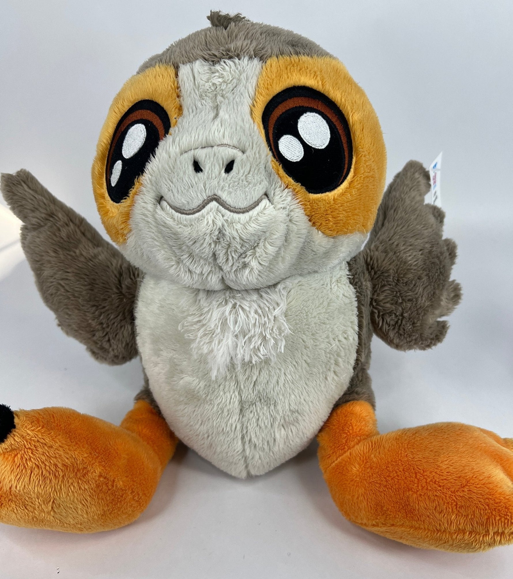 Porg-style plush dog toy with white fur, orange ear patches, and smiling face