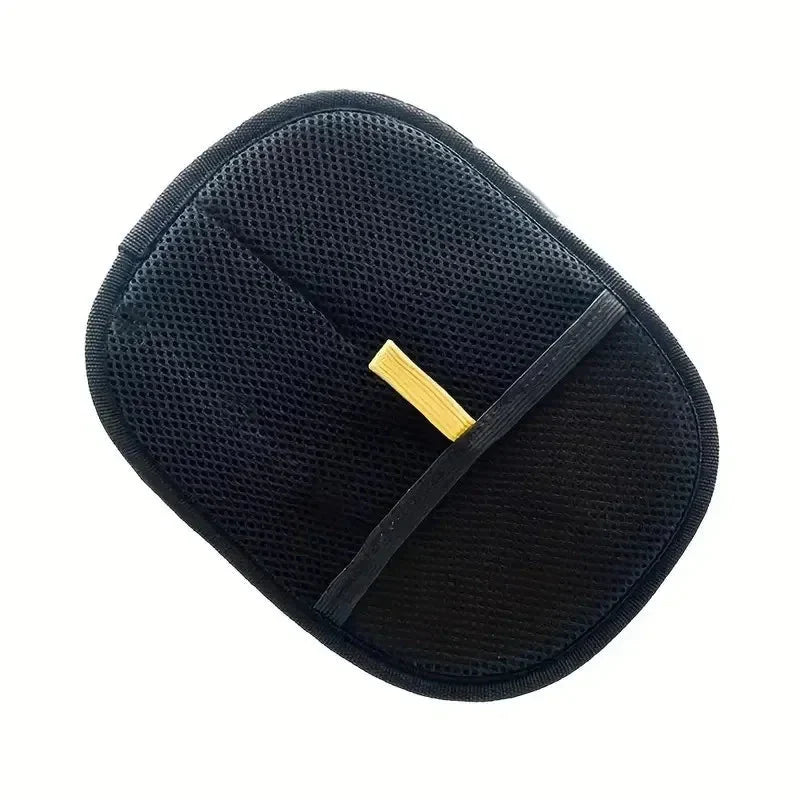 Black pet grooming hair removal glove with yellow tab, flat lay close-up
