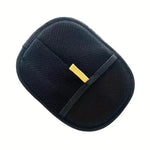 Black pet grooming hair removal glove with yellow tab, flat lay close-up