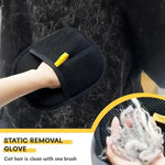 Black mesh grooming mitt with yellow tab and curved shape, hand shown brushing fur