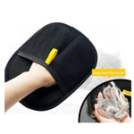 Black grooming mitt with yellow tab, hand brushing pet fur for hair removal