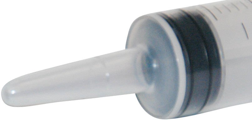 Syringe catheter tip with dark rubber connector and clear nozzle, close-up