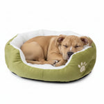 Green round pet bed with white plush liner and paw emblem, dog sleeping inside