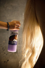 Horse tail and mane detangler spray bottle held beside a horse’s long mane