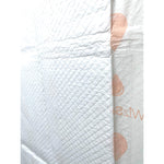 Off-white training pad with quilted absorbent surface and a visible seam line