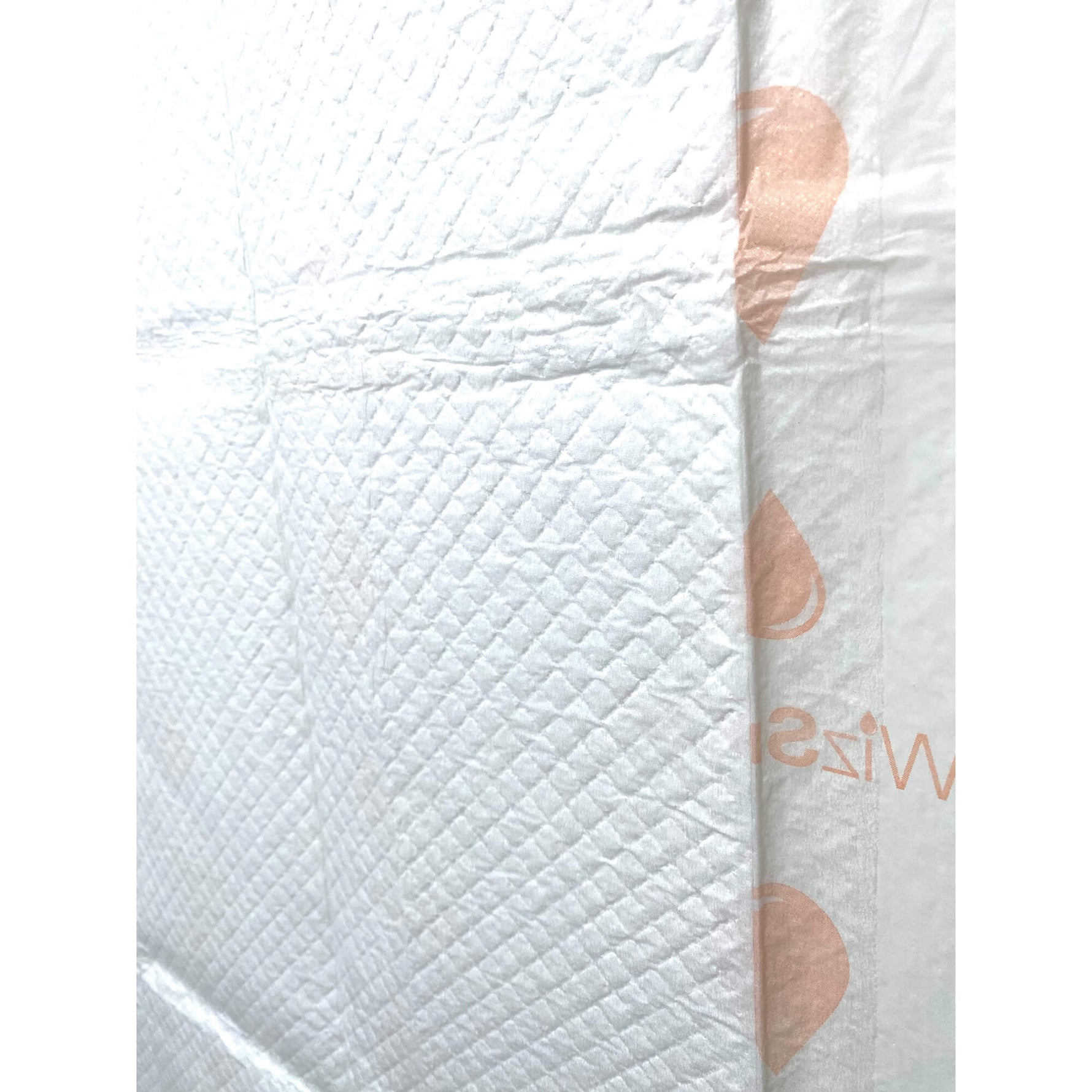 Off-white training pad with quilted absorbent surface and a visible seam line
